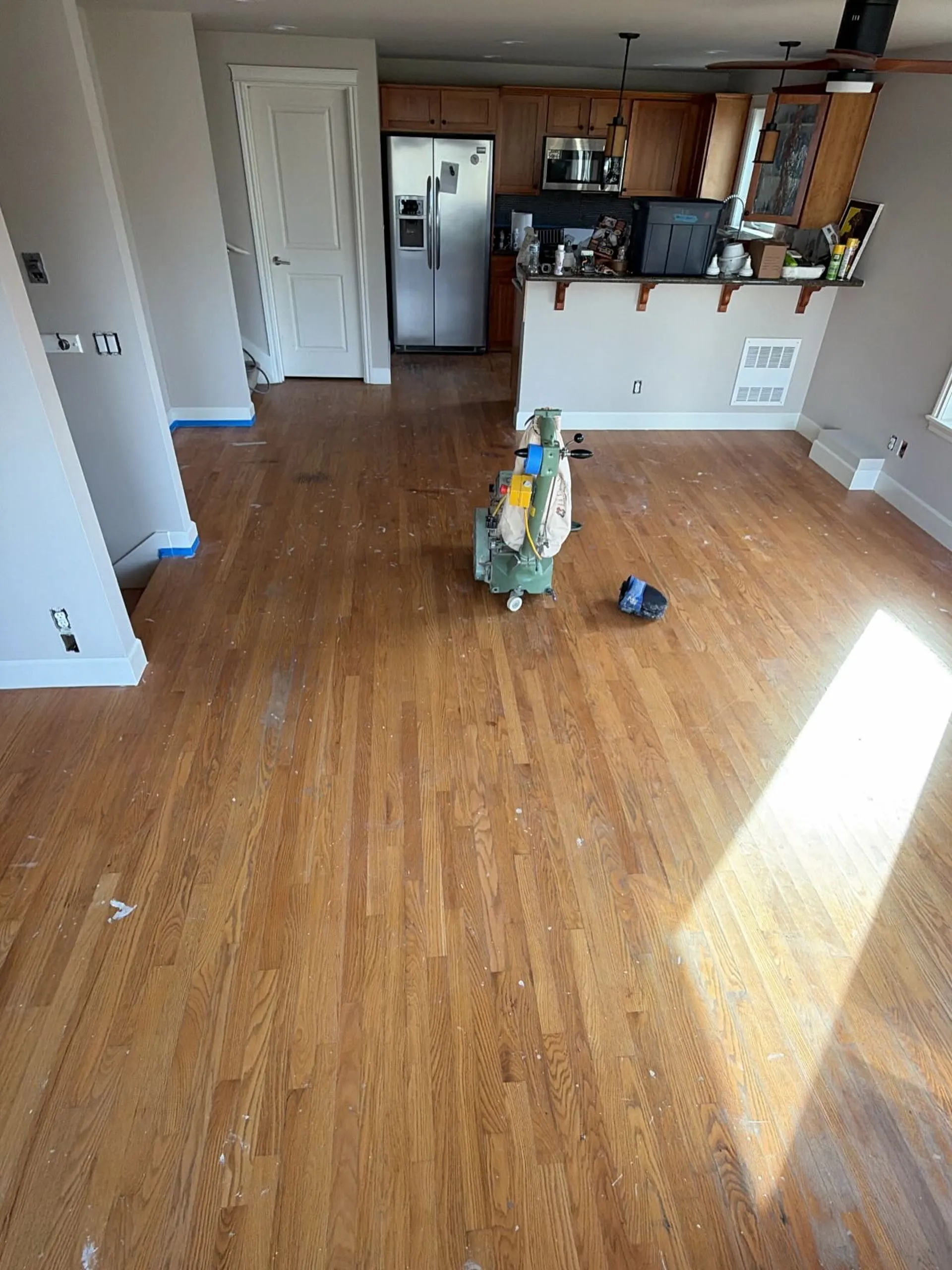 Parquet à lames droites dans une pièce ouverte sur la cuisine, avant rénovation