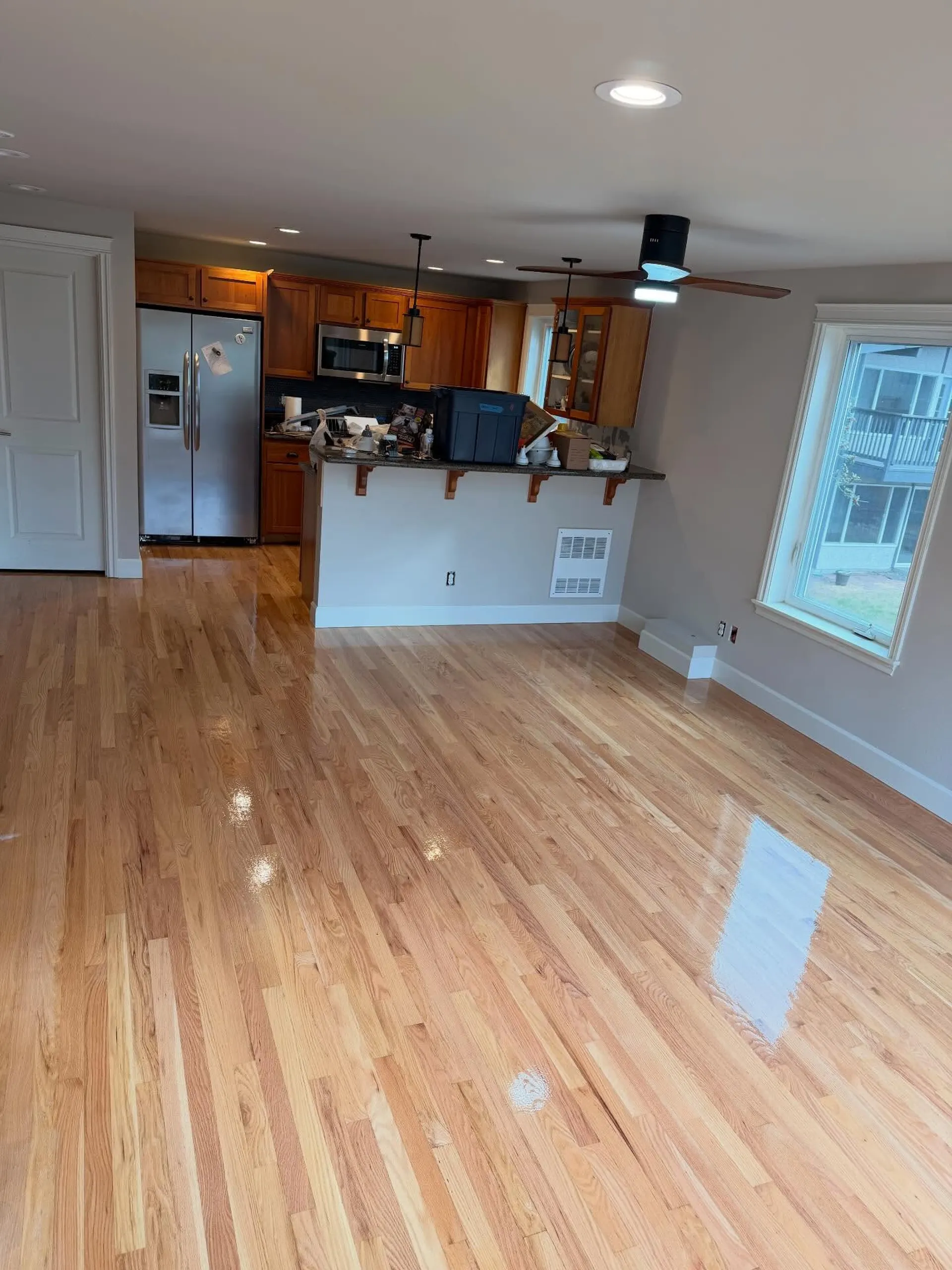 Parquet à lames droites dans une pièce ouverte sur la cuisine, après rénovation